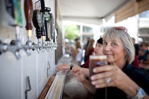 a volunteer pours a pint at one of the beer stations